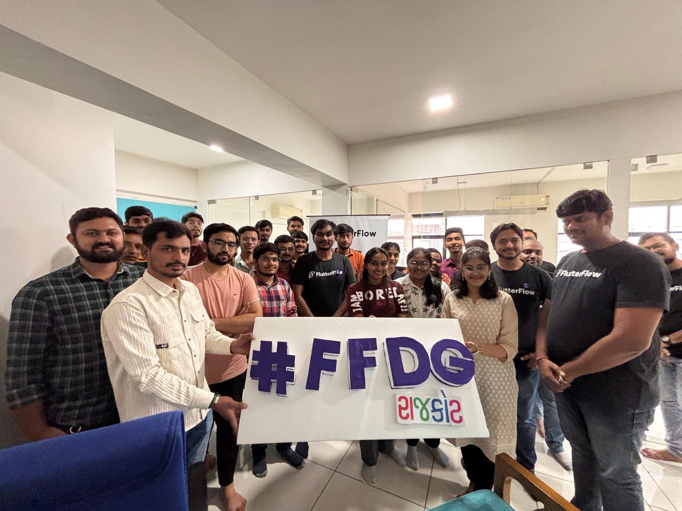 FFDG Rajkot organisers and community members gathered around the event sign