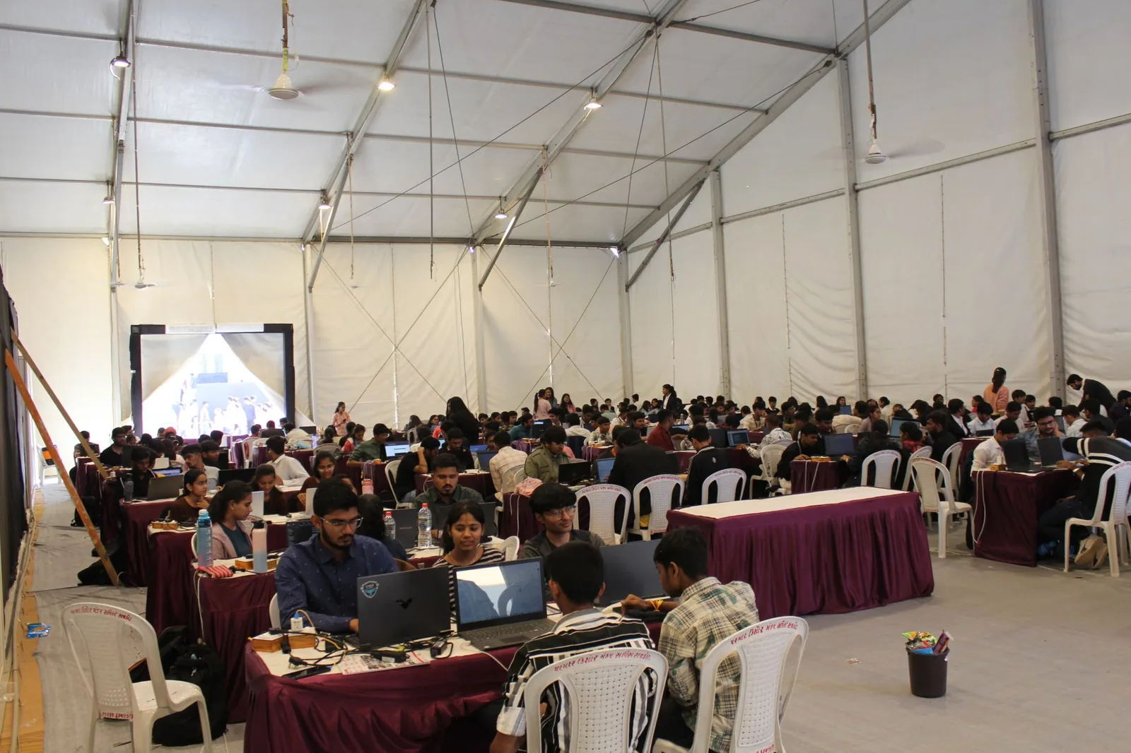 Students collaborating at tables during a large technology event