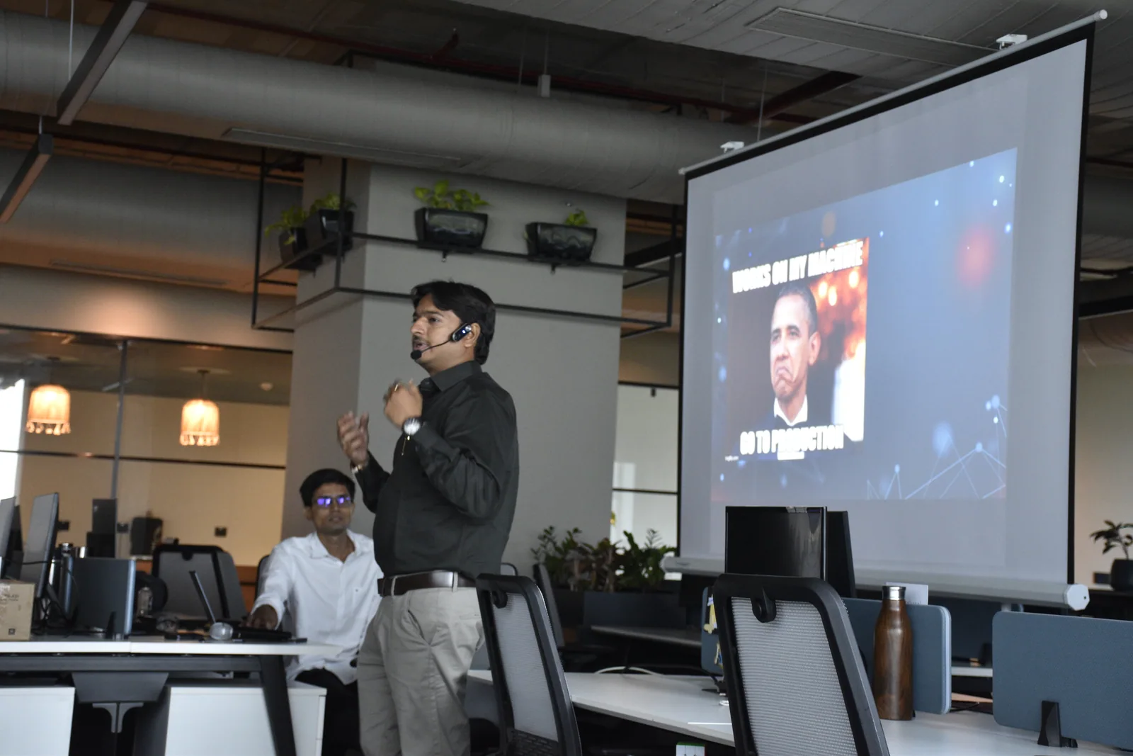 Jaydeep Adesara explaining a quality assurance concept beside a presentation screen